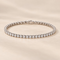 2.5mm round moissanite tennis bracelet in 925 sterling silver on warm ivory background