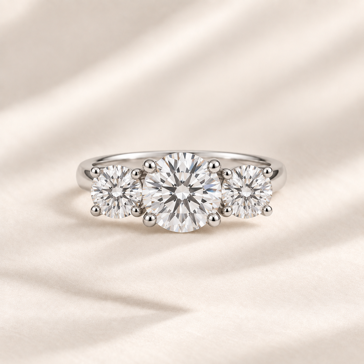 Philologi round moissanite three-stone ring with 2ct centre and 1ct side stones on warm ivory silk